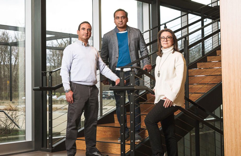 3 employees standing around a stair case