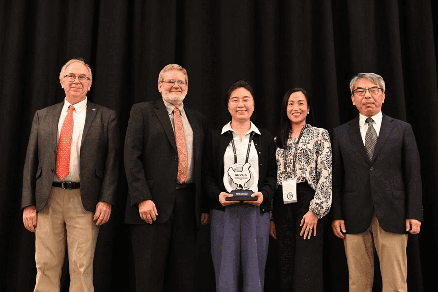Professor Jiangxia Zheng, Ph.D. (center) presented with the NOVUS International Teaching Award during the Poultry Science Association meeting in China.